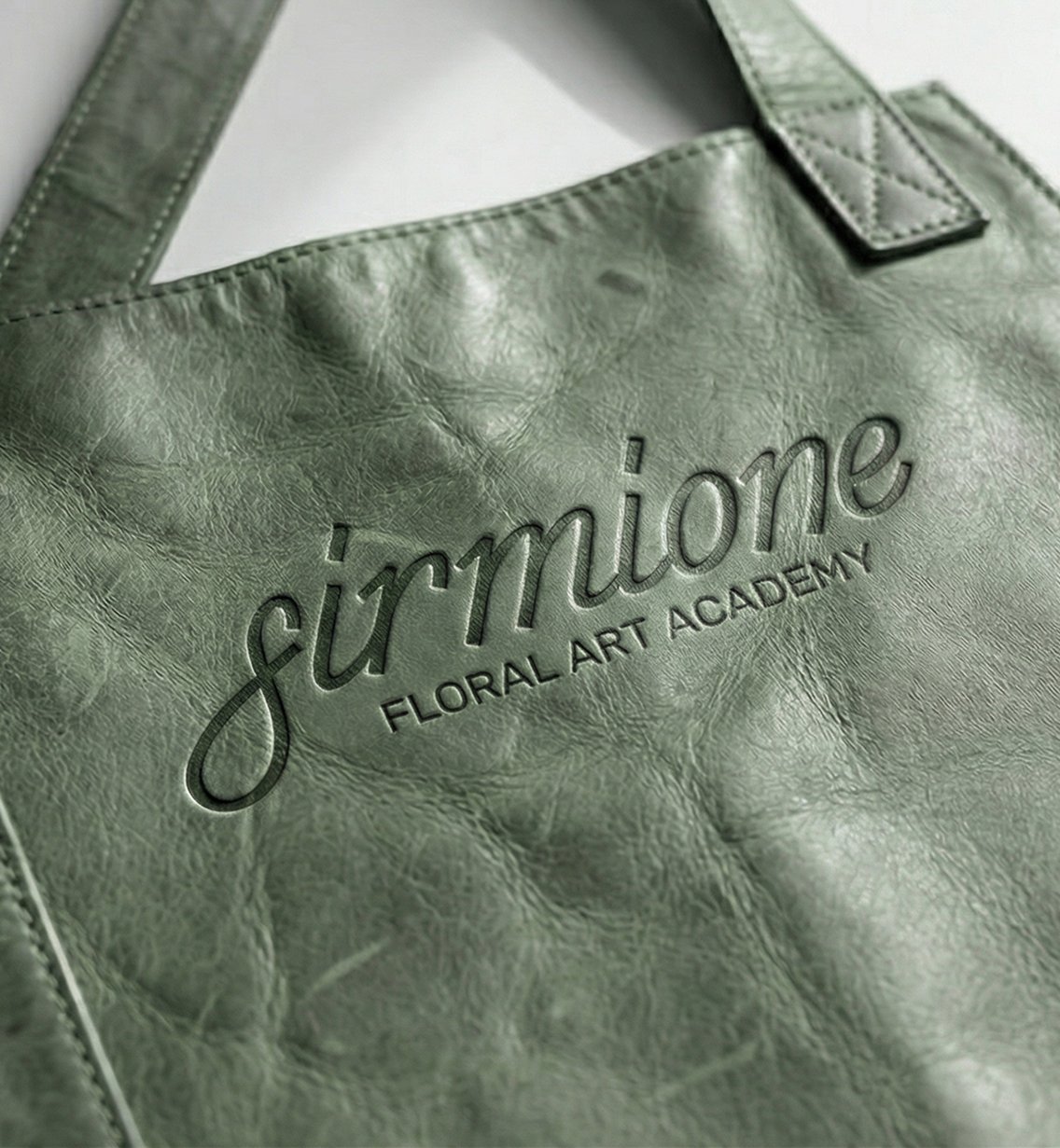 Green leather tote bag embossed with Sirmione logo
