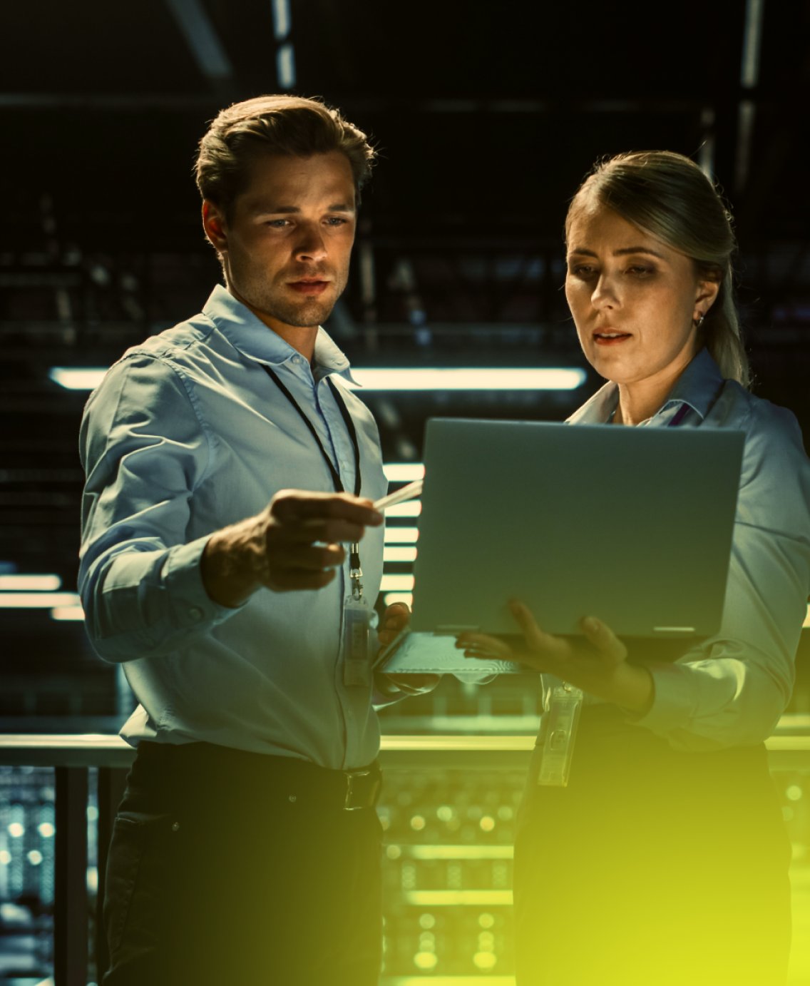 Two specialists with a laptop in a data center
